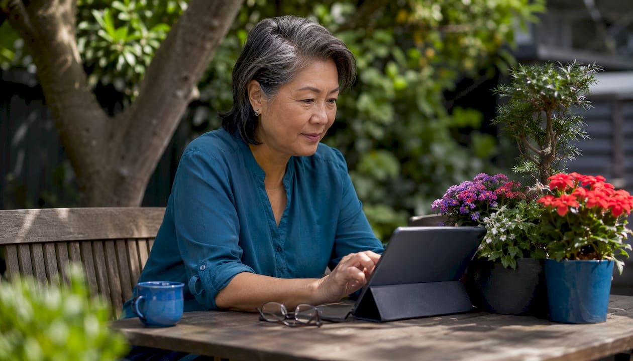 Woman using tablet in home kitchen workspace