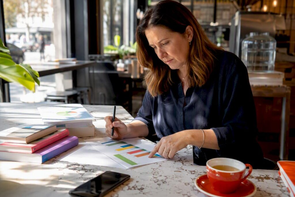 Business owner studying marketing charts on table