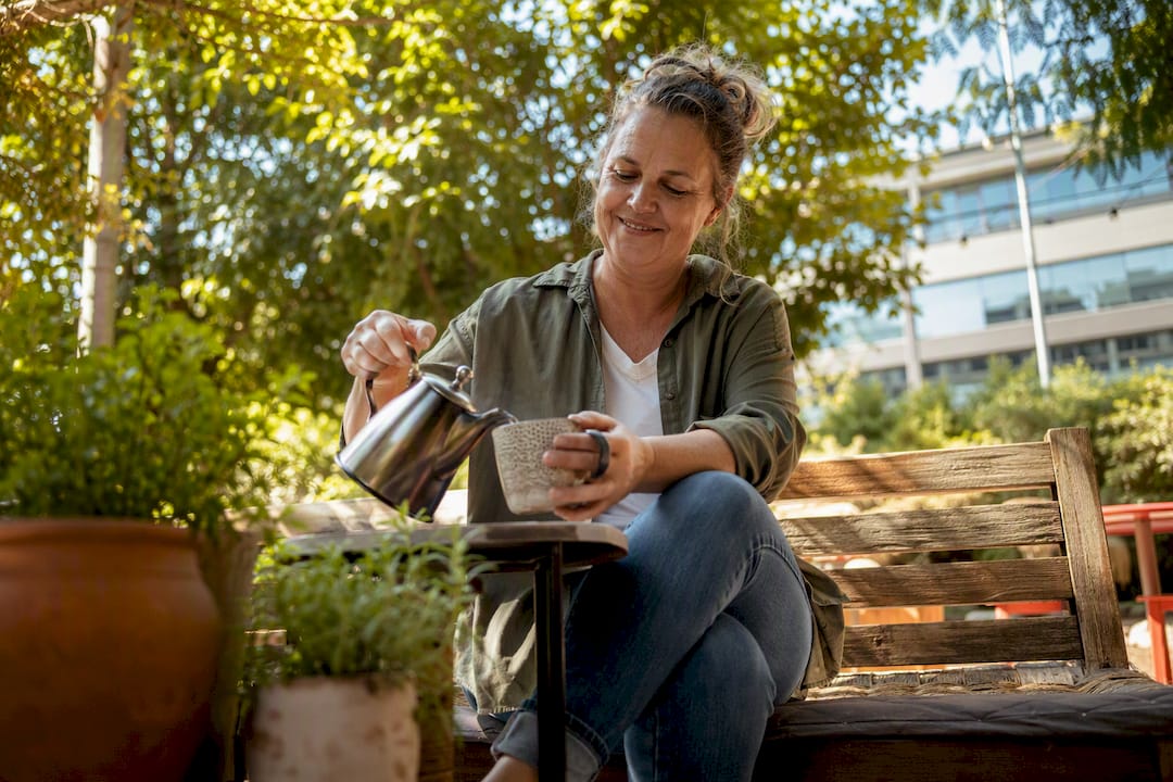 Business owner pouring coffee in casual outdoor setting